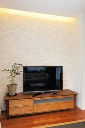 間接照明と壁面のエコカラット、TVボードがおしゃれな空間